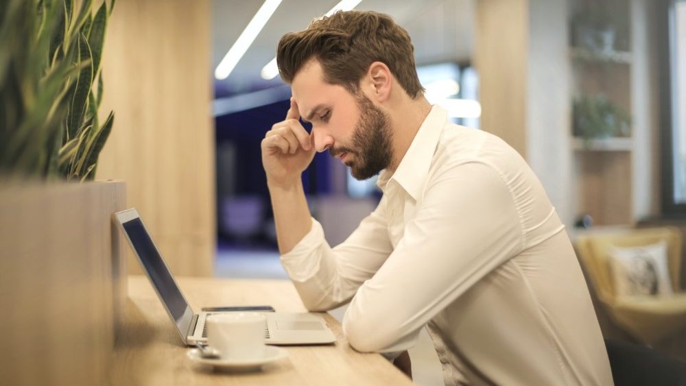 Man sitting at desk assessing trust based on online presence